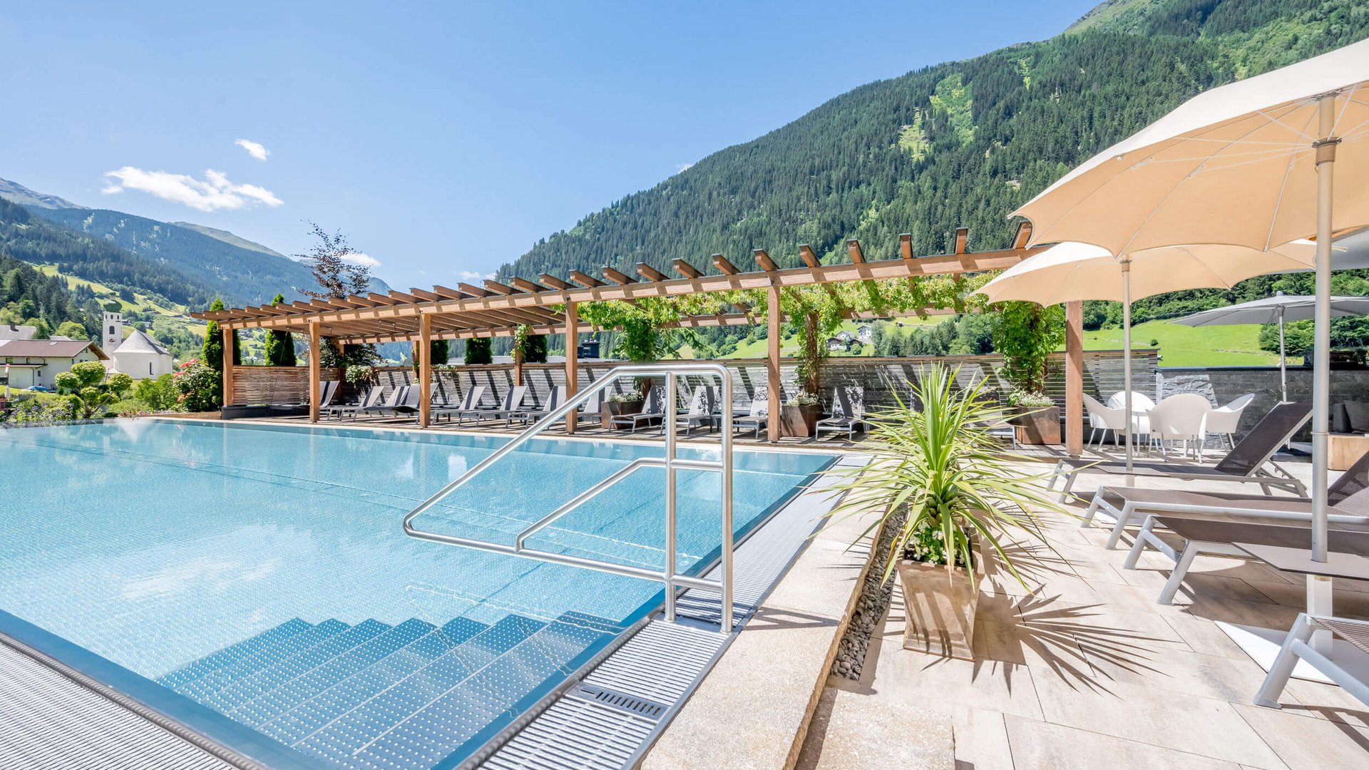 South Tyrol © Stephanie Maria Lohmann Beautiful swimming pool with mountains and lounge chairs on a clear day