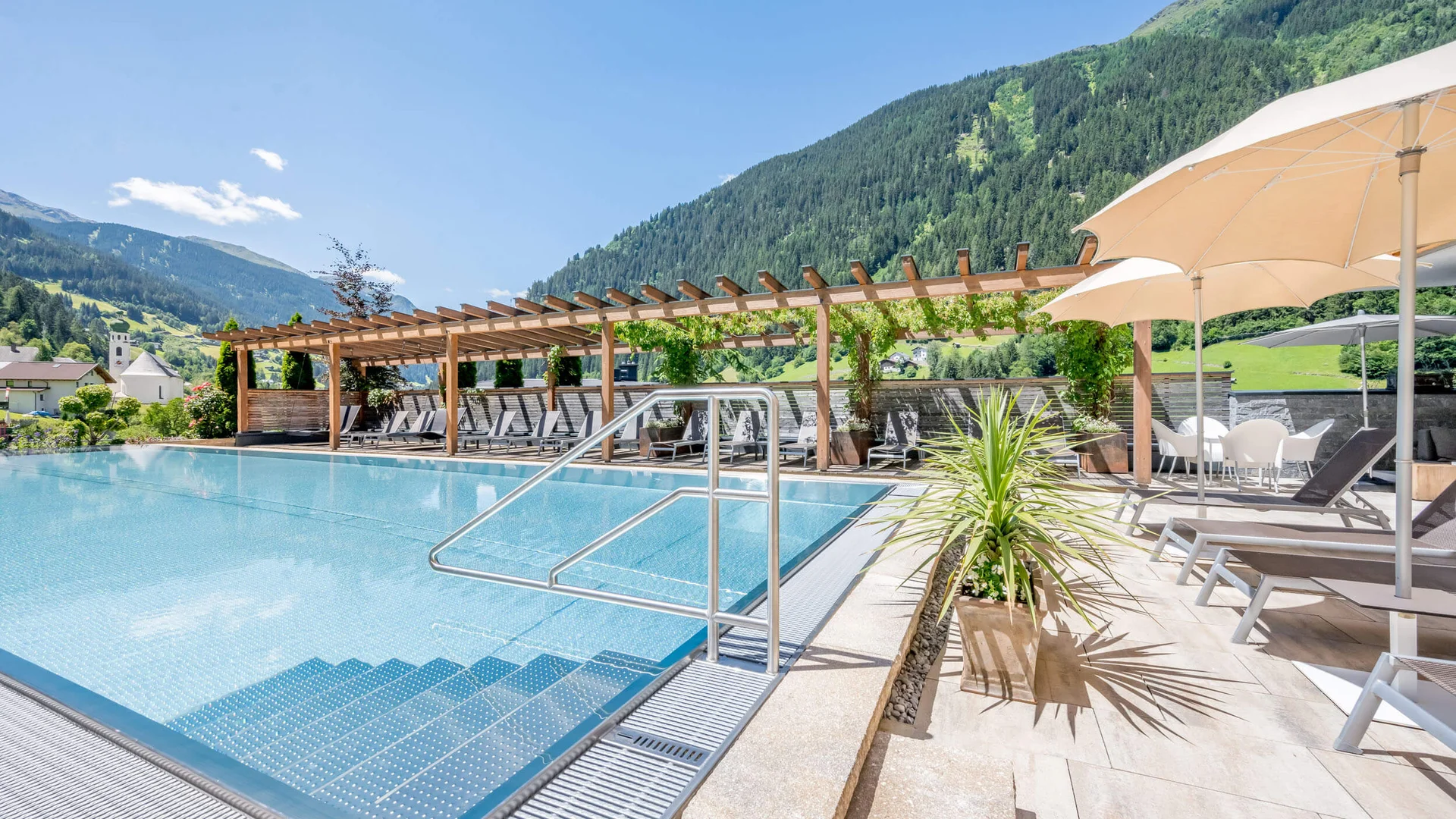 Mountain Bike Holidays © Stephanie Maria Lohmann Schöner Swimmingpool mit Bergen und Sonnenliegen bei klarem Wetter