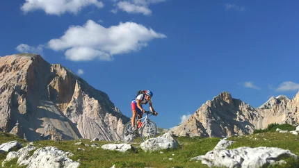 LARGE KRONPLATZ TOUR © Excelsior Dolomites Life Resort Mountain biker riding on rocky mountain trail under clear sky