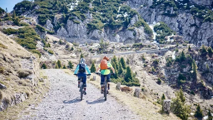 Lombardy © Tobias Köhler Two cyclists riding on a mountain trail with rocky terrain and pine trees