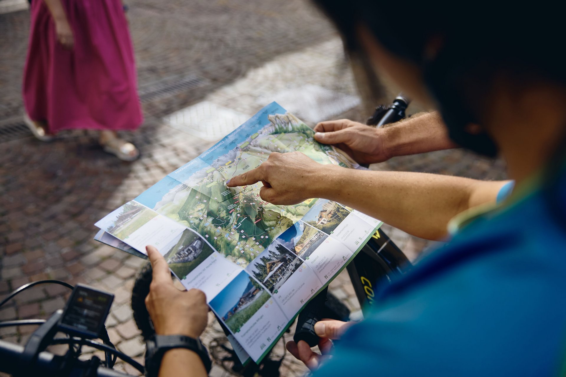 Mountain Bike Holidays © Tobias Köhler Person zeigt auf eine Landkarte beim Radfahren in einer Stadt