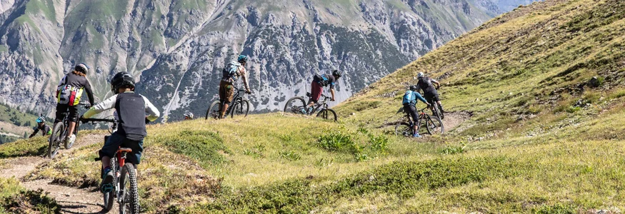 Livigno © Samuel Confortola Group of mountain bikers riding on a trail in alpine mountain landscape