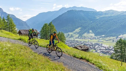 Enduro Natural Trail © Samuel Confortola Two mountain bikers riding on a mountain trail with scenic mountain views