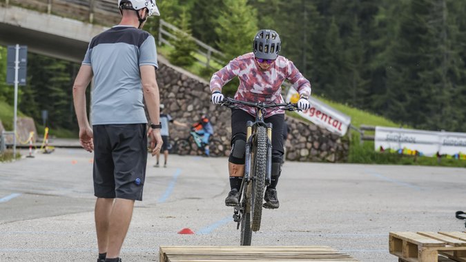 Mountain Bike Holidays © Jens Vögele - Westsiders Fahrradfahrer springt über Holzpalette bei Mountainbike-Training mit Trainer