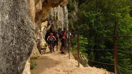 Natuur plezier Ronde © Bernhard Weissenhorn Fietsers op smal rotsachtig pad met beveiligingskabel en bos op de achtergrond