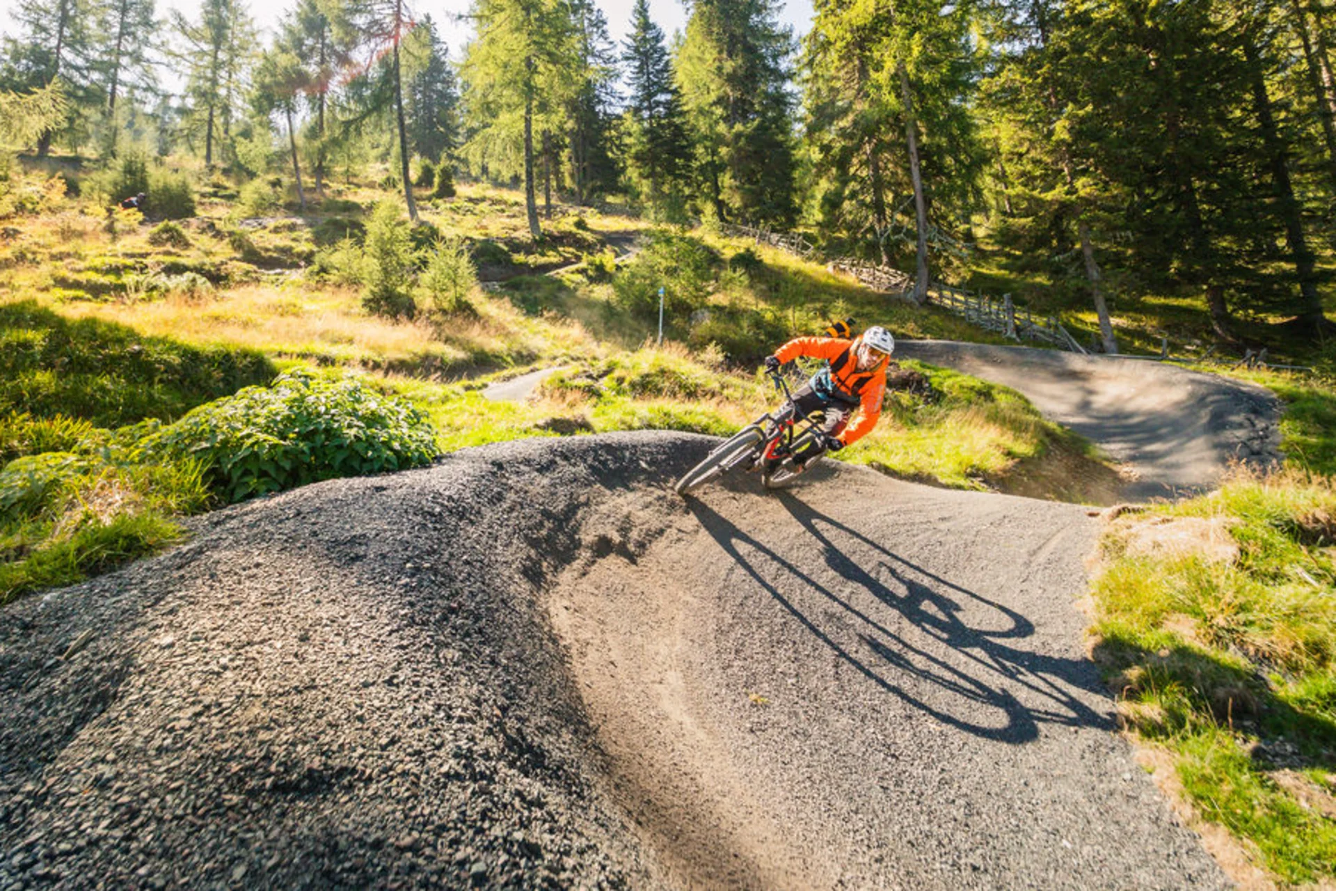 Mountain Bike Holidays © Millstätter See - Bad Kleinkirchheim - Nockberge Tourismusmanagement - Mathias Prägant Mountainbiker fährt kurvigen Waldweg bei sonnigem Wetter