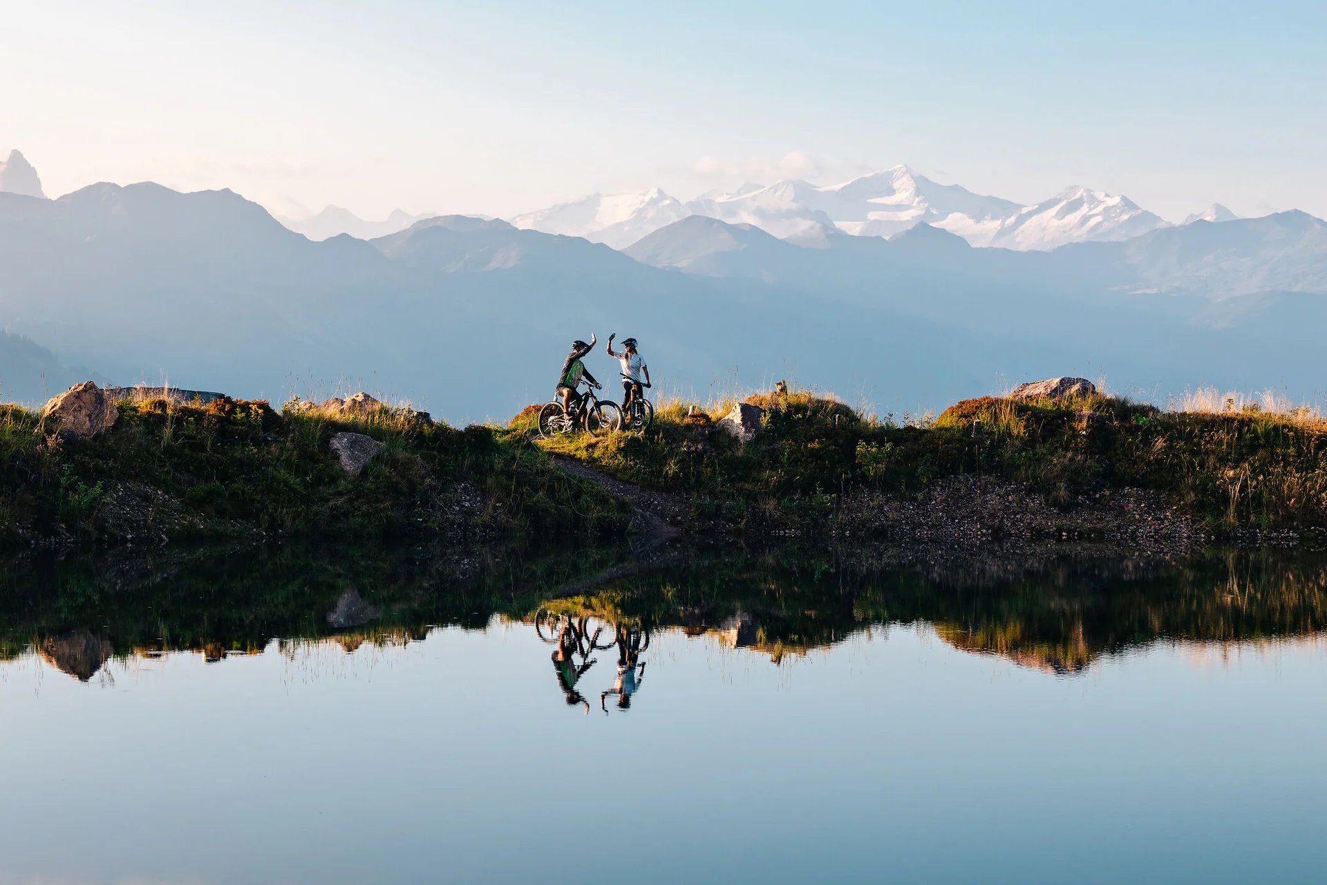 Mountain Bike Holidays © Mathäus Gartner Zwei Mountainbiker feiern mit Bergblick am Seeufer