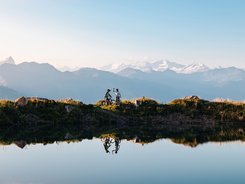 Kitzbühel Alps - Hohe Salve © Mathäus Gartner Two mountain bikers celebrating with mountain view by the lake