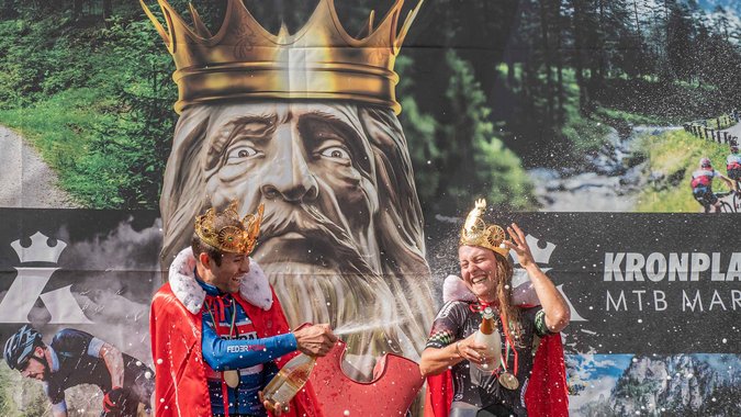 Mountain Bike Holidays Zwei Radfahrer feiern mit Kronen und Umhängen nach MTB-Marathon-Sieg