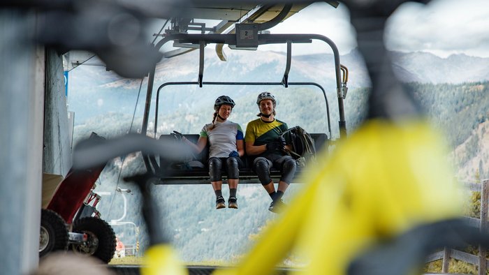 Biking as a group © David Karg Two cyclists on chairlift overlooking mountains