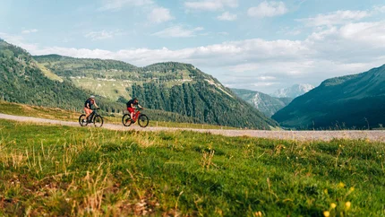 Sarstein ronde © Moritz Hübner Twee wielrenners op een bergpad met groene heuvels en bewolkte lucht