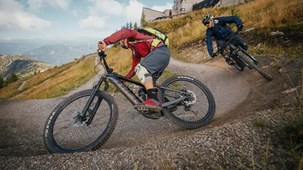 Double - Flow Country Trail rondreis vanuit Bad Kleinkirchheim © Felix Saller Twee mountainbikers rijden een kronkelig grindpad bergaf