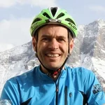 Mountain Bike Holidays © Hotel Pider Mann in Fahrradhelm vor schneebedeckten Bergen