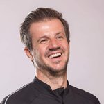 Mountain Bike Holidays © WOM Medien Mann mit Mountainbike-Urlaub-Shirt lächelnd vor neutralem Hintergrund