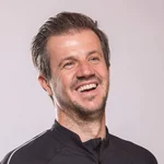 Mountain Bike Holidays © WOM Medien Mann mit Mountainbike-Urlaub-Shirt lächelnd vor neutralem Hintergrund