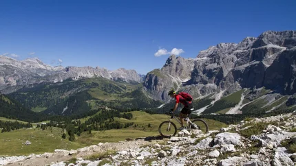 HL. CROSS - ROUND © Hotel Pider Mountain biker rides on rocky trail in mountains under clear blue sky