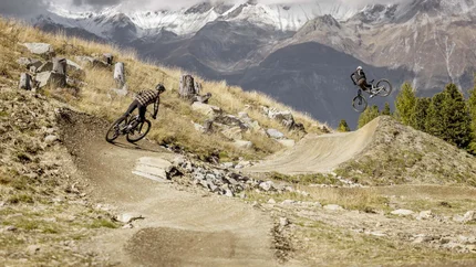Goldseetrail © Rudi Wyhlidal Two mountain bikers riding on a trail with snowy mountain peaks in the background