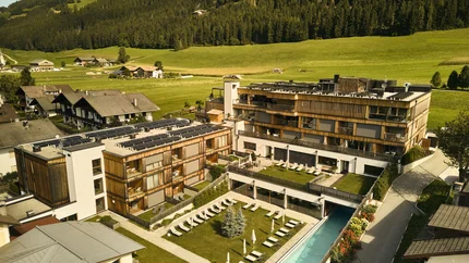 HIRBEN Naturlaub © David Rasche Hotelanlage mit Schwimmbad und Liegestühlen in grüner Berglandschaft