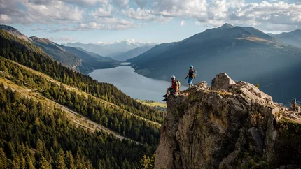 Plamorttrail © Felix Saller Two hikers on rocks overlooking mountains and a lake