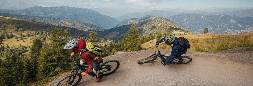Weissensee © David Karg Two mountain bikers riding on a winding mountain trail