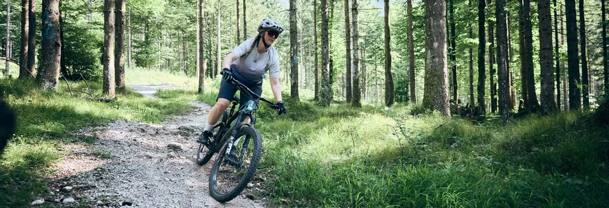 Mountain bike holidays in Styria © Tobias Köhler Woman mountain biking on forest trail wearing helmet and sunglasses
