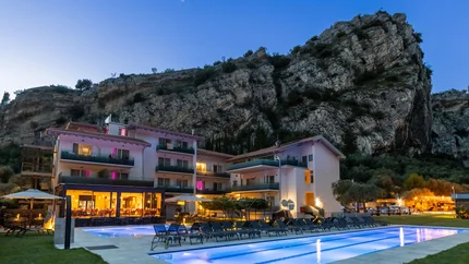 AktivHotel SantaLucia Gardasee © Fabio Staropoli Hotel mit beleuchtetem Pool am Abend vor einem großen Felsen