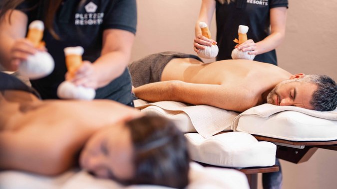 Mountain Bike Holidays © Daniel Waschnig Zwei Personen erhalten Kräuterstempelmassagen in einem Spa