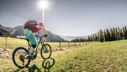 Kerschbaumer Saddle © Kerschbaumer Woman riding mountain bike on green meadow under sunny mountain sky