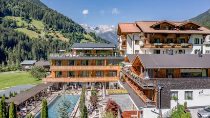 Hotel Weisses Lamm © Stephanie Maria Lohmann Modernes Hotel in den Bergen mit Außenpool und Terrasse bei sonnigem Wetter