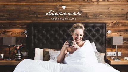Alpines Gourmet Hotel Montanara © Anja Koppitsch Photography Frau lächelnd im Bett mit Tasse und Schriftzug entdecken und verlieben