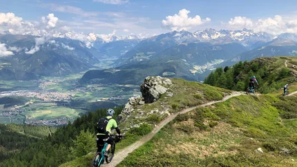 Kronplatz Summit © Hotel Innerhofer Mountain bikers riding trail with view of Alps and valley below