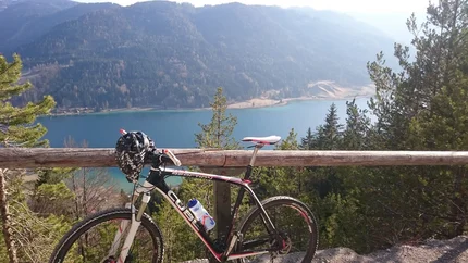 Weisse Wand - alpenweide achter Brunn © Regitnig GmbH Mountainbike bij meer met beboste bergen in zonlicht