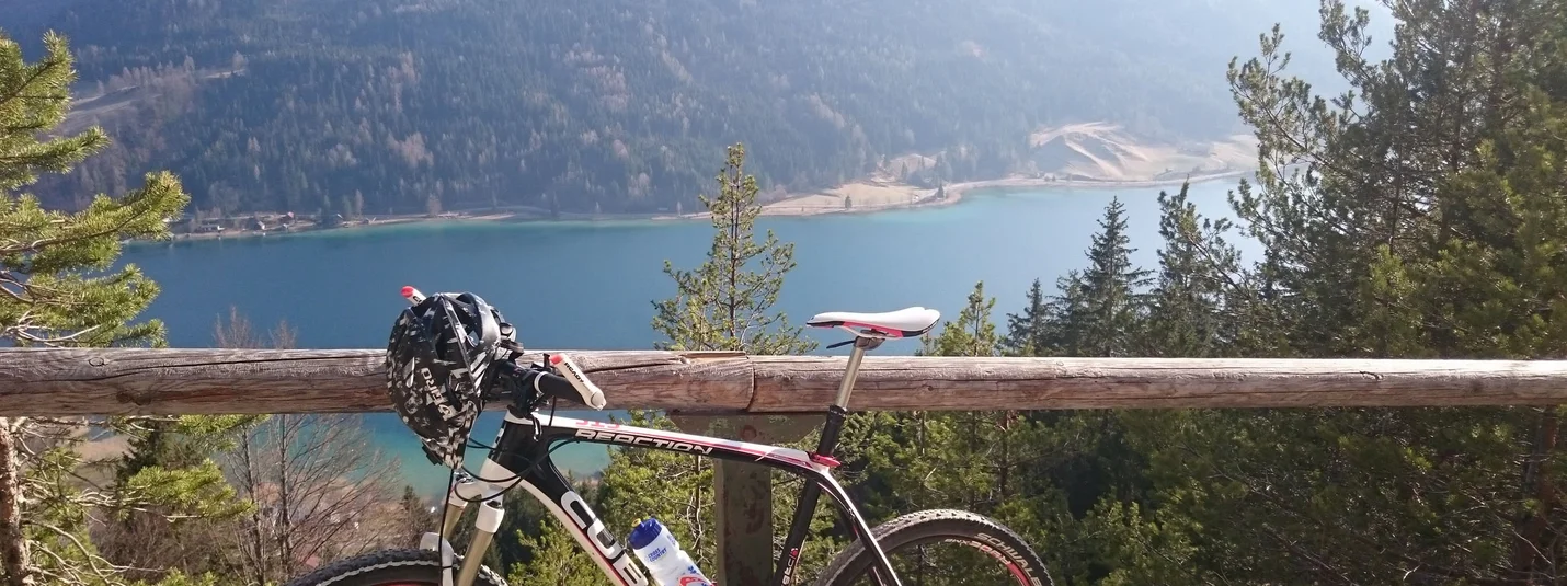 Weisse Wand - alpenweide achter Brunn © Regitnig GmbH Mountainbike bij meer met beboste bergen in zonlicht