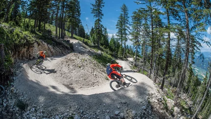 JAMNICA - PETZEN FLOW TRAIL © Urosh Grabner Mountain bikers riding on a winding forest trail in sunny weather