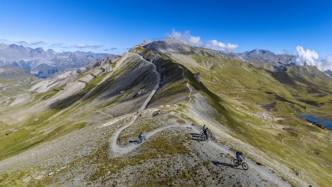 Mountain Bike Holidays © TVB Paznaun-Ischgl Mountainbiker auf einem Höhenweg in alpiner Landschaft bei klarem Himmel
