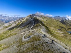 Bike region Paznaun - Ischgl © TVB Paznaun-Ischgl Mountain bikers riding on a ridge trail in alpine mountain landscape under blue sky