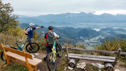 PLANINA KOFCE © David Karg Two cyclists on mountain overlooking valley and mountains