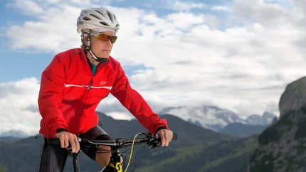 JUVEL TOUR © Davide dal Mas Woman in red jacket and helmet riding mountain bike in mountainous landscape