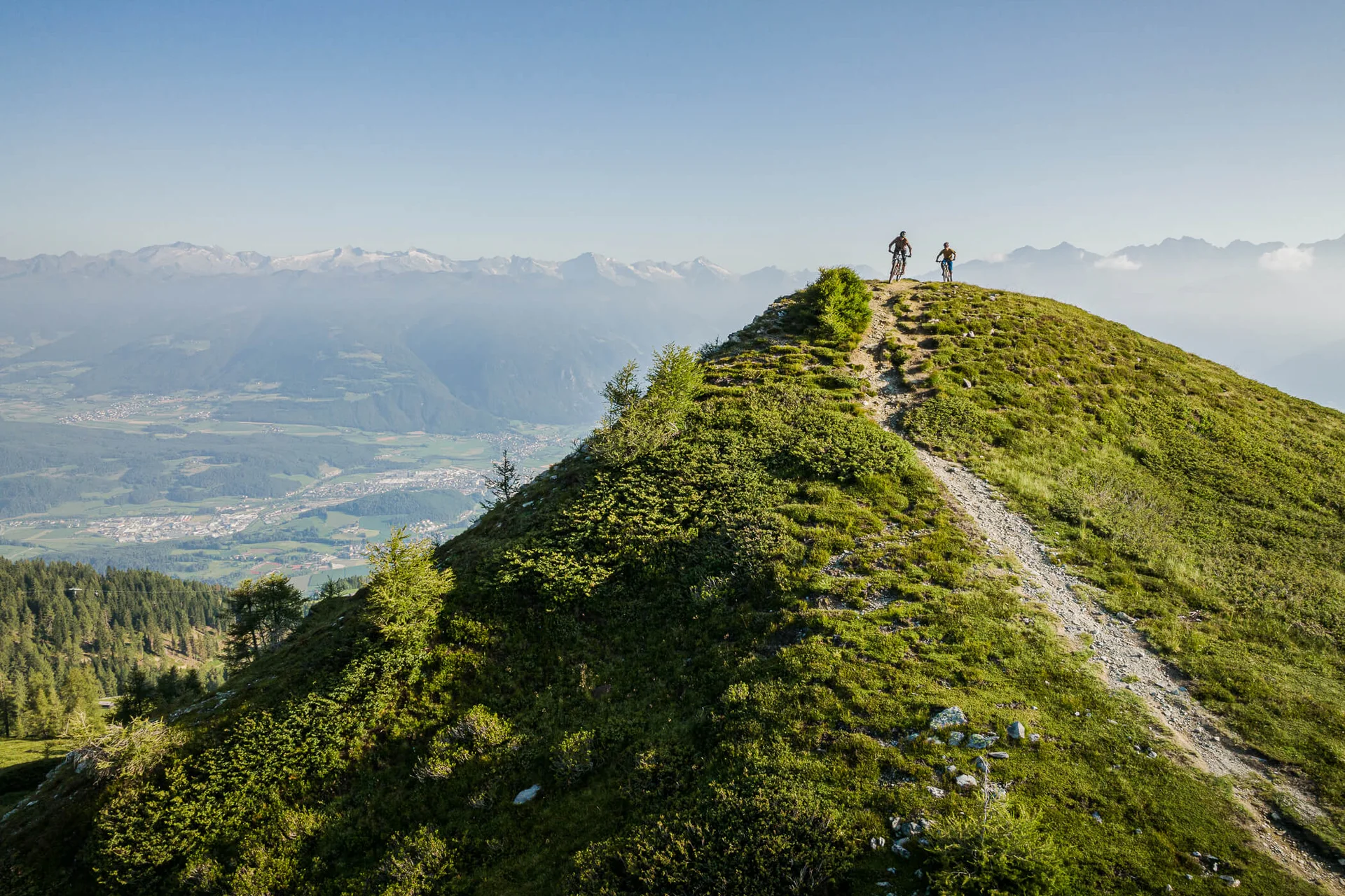 Mountain Bike Holidays © Harald Wisthaler Zwei Radfahrer auf einem bergigen Wanderweg mit Tal- und Bergsicht