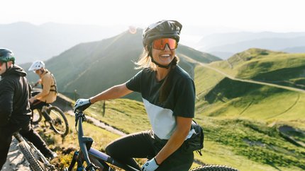 Saalbach Hinterglemm Leogang Fieberbrunn © Saalbach.com - Moritz Ablinger Woman with mountain bike and helmet on sunny mountain trail