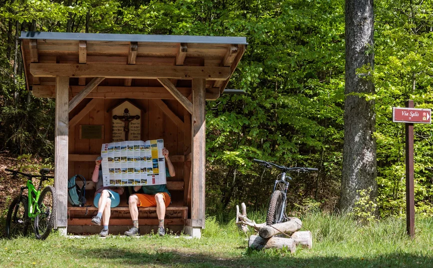 Mountain bike holiday in the Salzkammergut © Bikeboard.at - Erwin Haiden Couple reading hiking map in wooden shelter next to bikes in forest