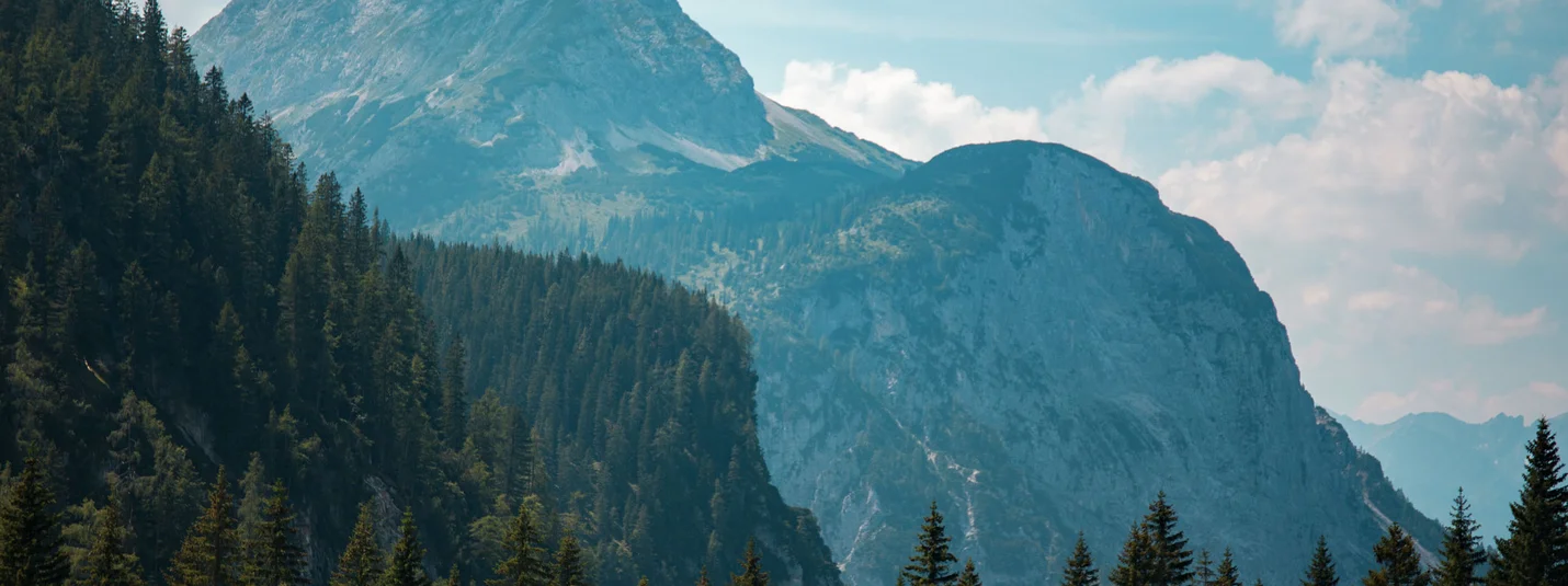 FROM GARMISCH AROUND THE WETTERSTEINGEBIRGE © David Karg Lake with mountain view and forest in sunlight