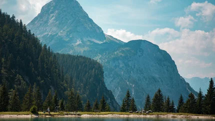 FROM GARMISCH AROUND THE WETTERSTEINGEBIRGE © David Karg Lake with mountain view and forest in sunlight