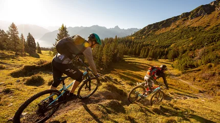 Loischkopf Tour © Michael Marte Two mountain bikers riding downhill in a sunny mountain landscape