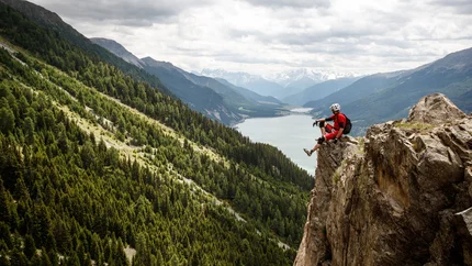 PLAMORT TOUR © Erwin Haiden Man sitting on rock overlooking mountains and lake