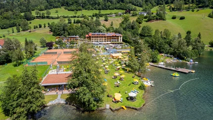 Familien- & Sportresort Brennseehof © Gert Perauer Luftaufnahme eines Ferienresorts am See mit Liegestühlen und Tennisplätzen
