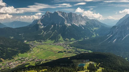 BIKE TRAIL TIROL STAGE EHRWALD - SCHARNITZ © Hotel Ehrwalderhof View over green valley with mountain village and towering mountains in the background