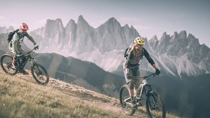 Sky Line and Rock Line © Brixen Tourismus - Manuel Kottersteger Two cyclists riding mountain trail with rocky peaks in background