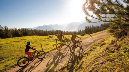 Short Tour around the Loischkopf © Michael Marte Three mountain bikers riding on a forest path in sunny mountain landscape
