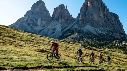 SELLARONDA (CLOCKWISE) © Szymon Bike Five mountain bikers riding on a trail with rocky mountains in the background